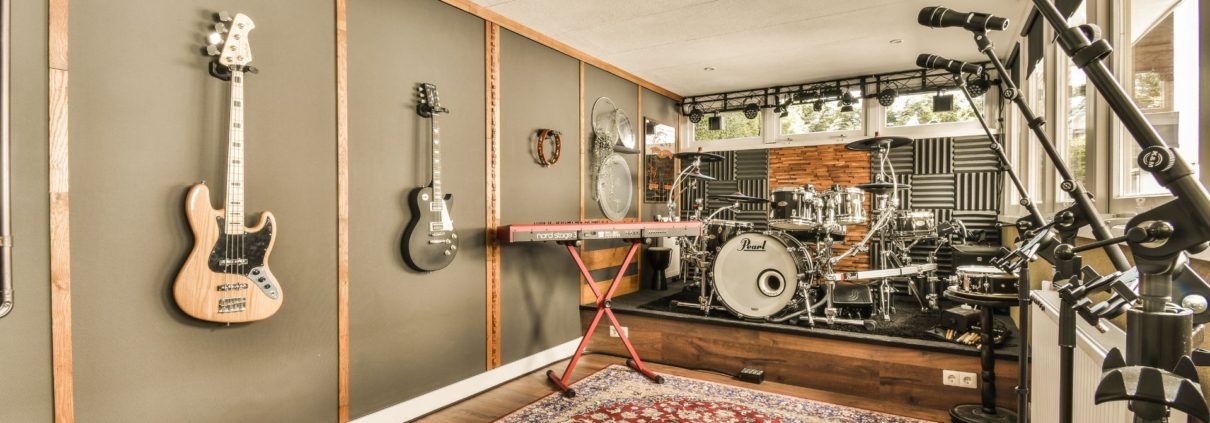 basement music room with guitars on the wall and a drum set - We Finish Basements