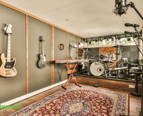 basement music room with guitars on the wall and a drum set - We Finish Basements